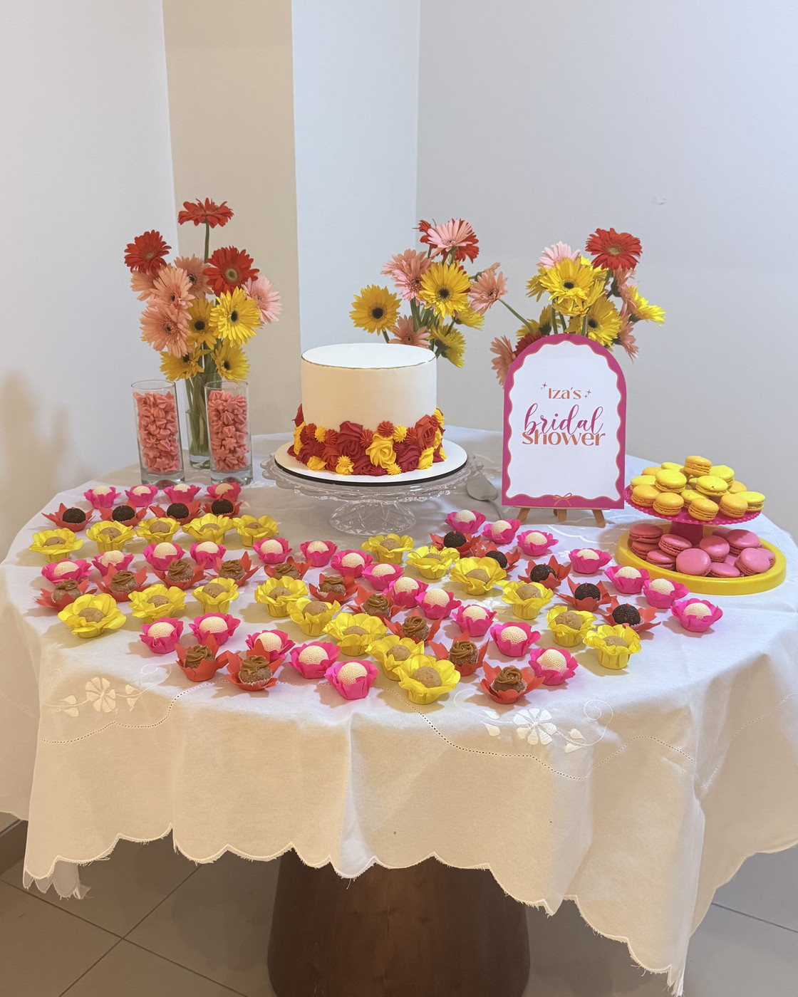 Mesa de bridal shower com placa personalizada, flores e macarons
